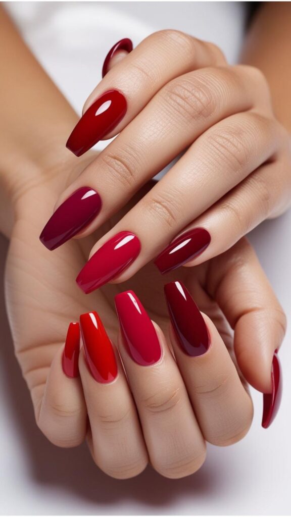 Hands with perfectly manicured red nails, showcasing various shades of red
